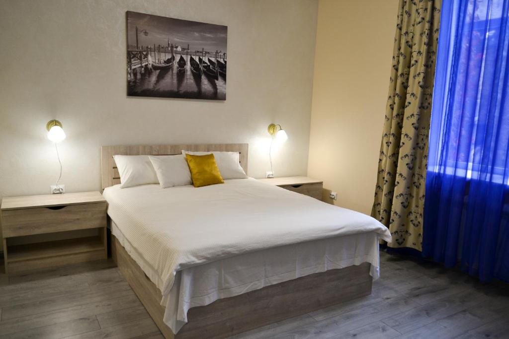 um quarto com uma cama, 2 candeeiros e uma janela em Aquamarine apartments Lviv em Lviv