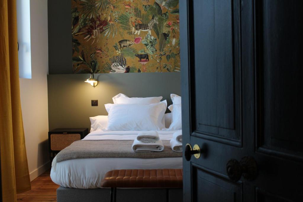 a bedroom with a bed with a painting on the wall at Maison Caju - La Rochelle in La Rochelle