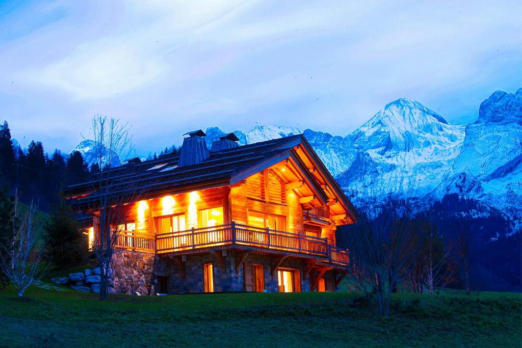 une cabane en rondins dans les montagnes la nuit dans l'établissement Chalet La Vigogne et Spa, au Grand-Bornand