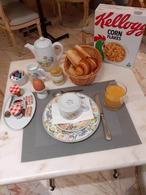 a table with plates of food and a box of orange juice at Hôtel La Sanguine in Paris