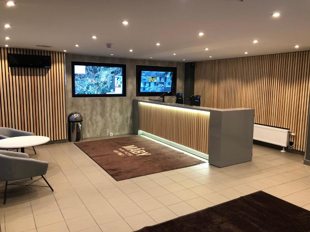 a waiting room with two monitors on the wall at Måby Park & Hotell in Arlanda