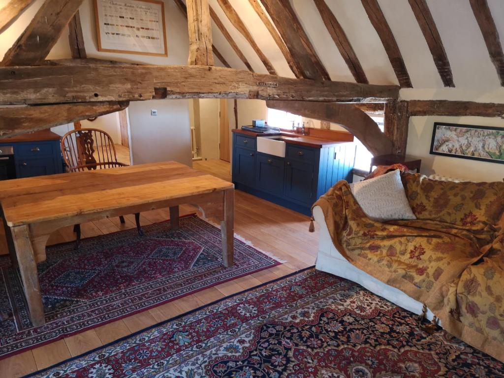 a living room with a wooden table and a couch at The Queen's Head in Hawkedon