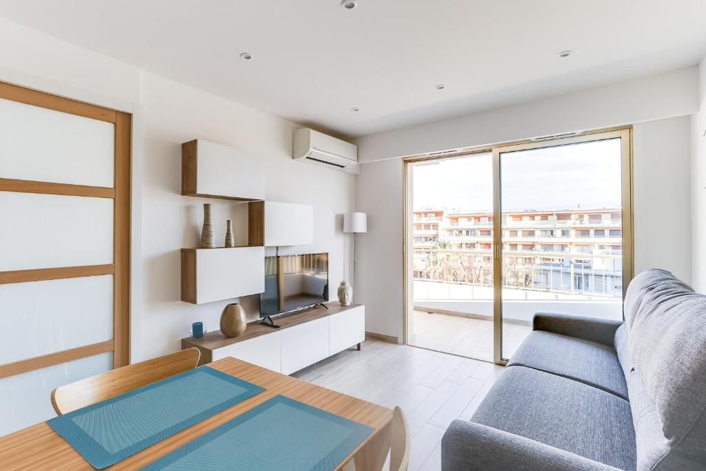 - un salon avec un canapé et une table dans l'établissement IMMOGROOM - Renovated apartment - Terrace - AC - Wifi, à Cannes