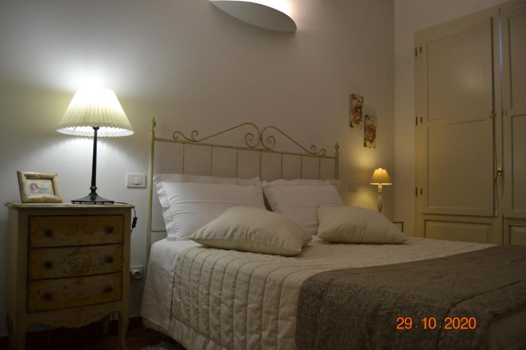ein Schlafzimmer mit einem Bett mit zwei Kissen und einer Lampe in der Unterkunft La Colombara - Fra i colli a 5 minuti dall'autodromo in Imola