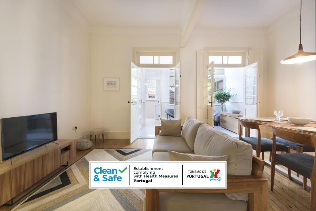 een woonkamer met een bank en een tv bij Tripas-Coração, Breiner GreenHouse in Porto