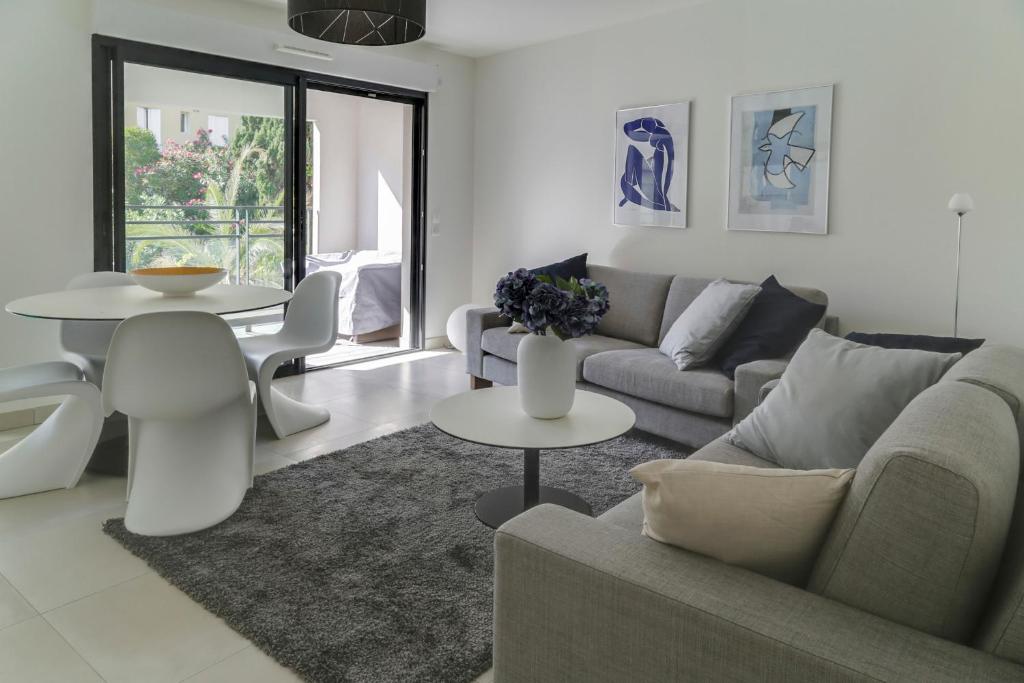 ein Wohnzimmer mit einem Sofa und einem Tisch in der Unterkunft IMMOGROOM- Modern - Elegant - Close to the beach -AC in Cannes