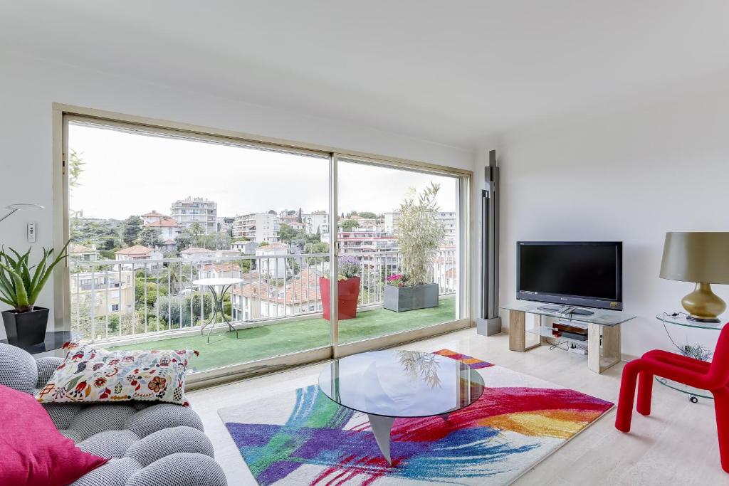 - un salon avec une table en verre et une grande fenêtre dans l'établissement IMMOGROOM - Apartment with terrace - AC - Parking, à Cannes