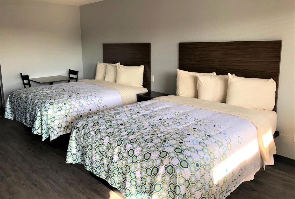 Dos camas en una habitación de hotel contigua en HomeTowne Studios by Red Roof San Antonio E - Frost Bank Center, en San Antonio