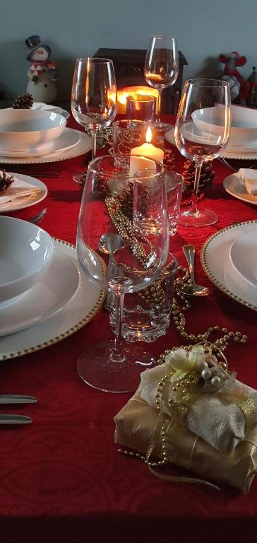 a red table with plates and glasses and a candle at Bay View House in Liscannor
