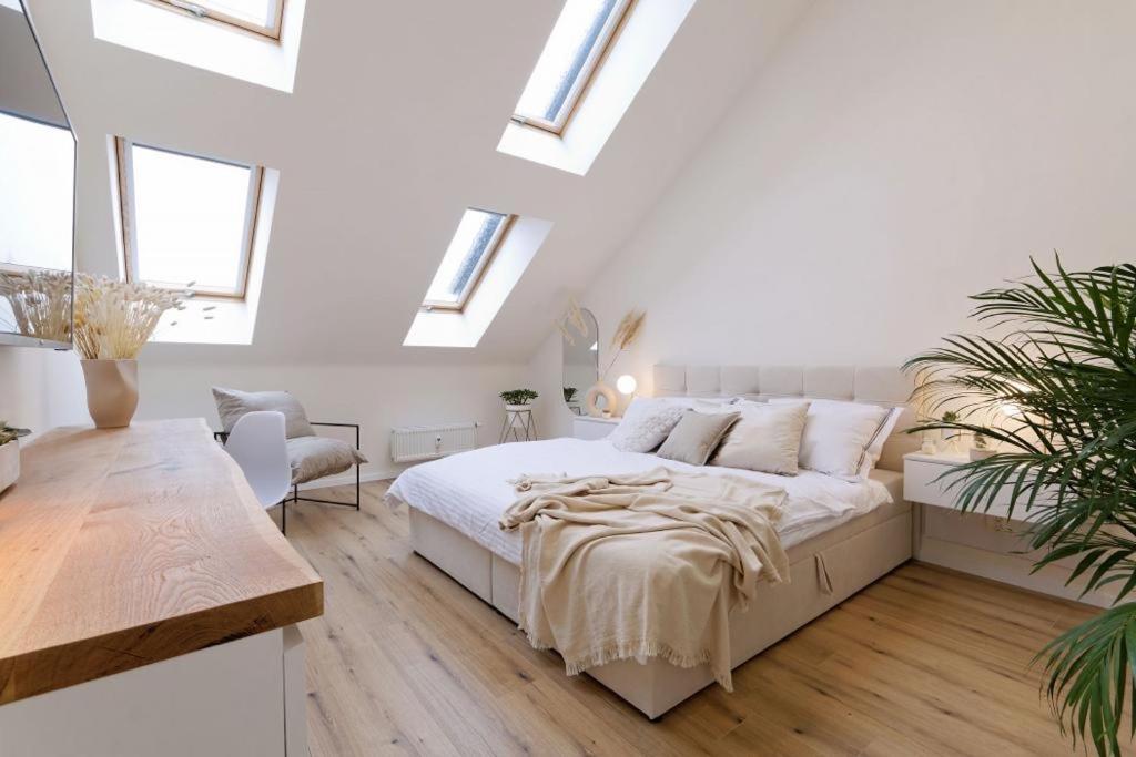 1 dormitorio blanco con 1 cama grande y tragaluces en New luxury main square apartment en Brno