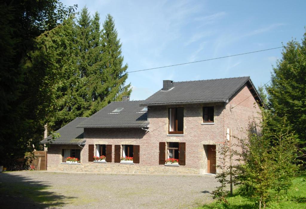 een stenen huis met een zwart dak bij Holiday Home Le Pihon in Gouvy