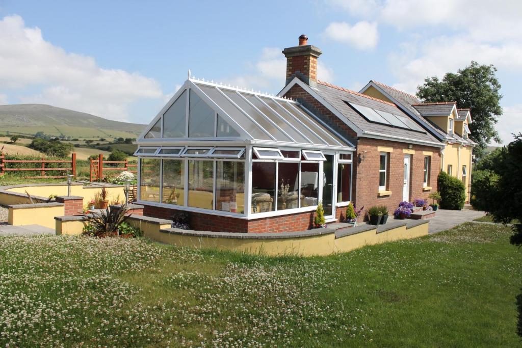 una casa con un salón acristalado con muchas ventanas en Brynhaul Bed and Breakfast, en Maenclochog