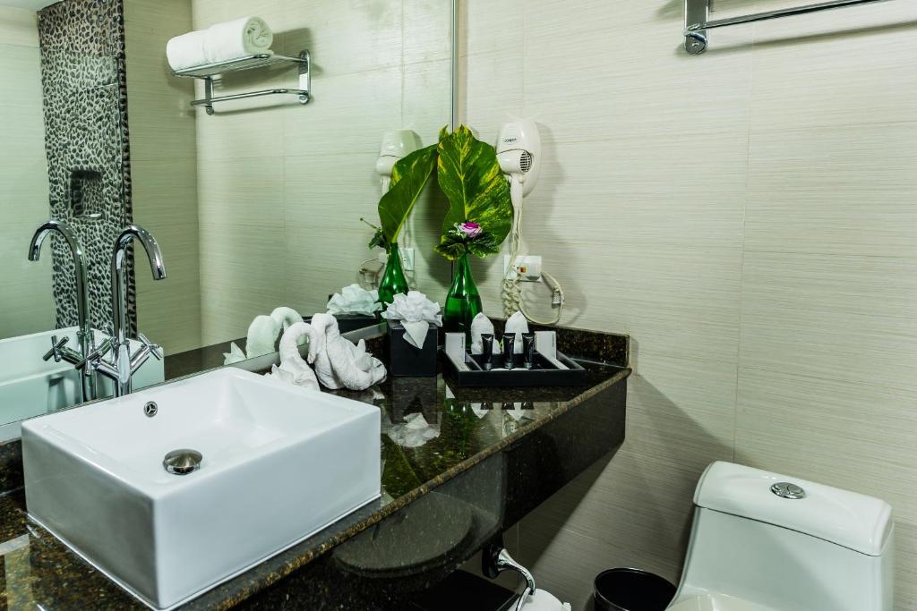 a bathroom with a white sink and a toilet at Riande Aeropuerto Hotel Casino in Tocumen