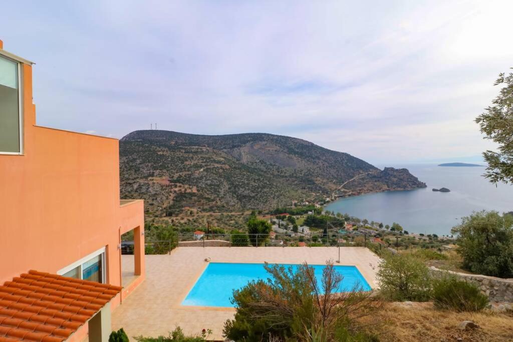 een villa met een zwembad en uitzicht op de oceaan bij Eagle Nest Villa in Antikyra