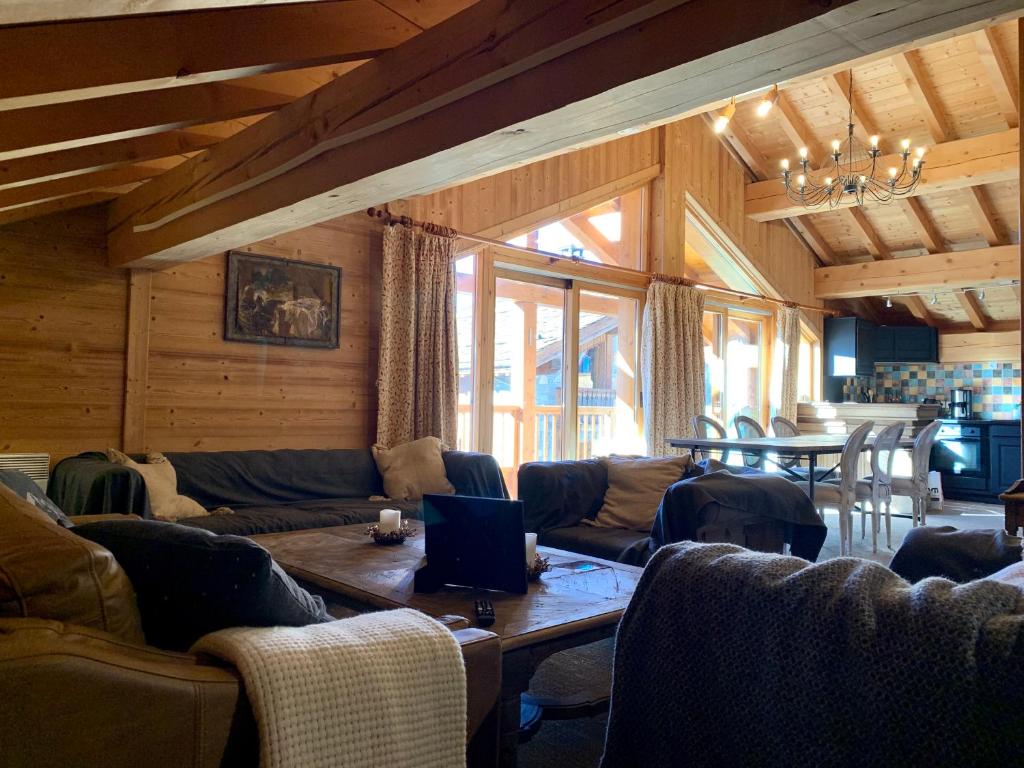 a living room with couches and a table with a laptop at Chalet Victoria in Sainte-Foy-Tarentaise