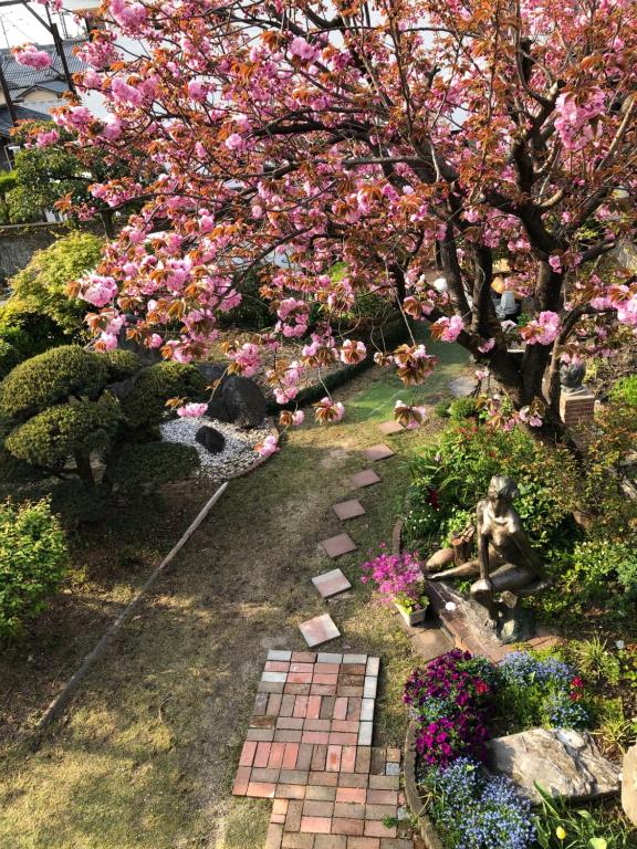 ogród z różowymi kwiatami i ścieżką w obiekcie Sakura house w mieście Kioto