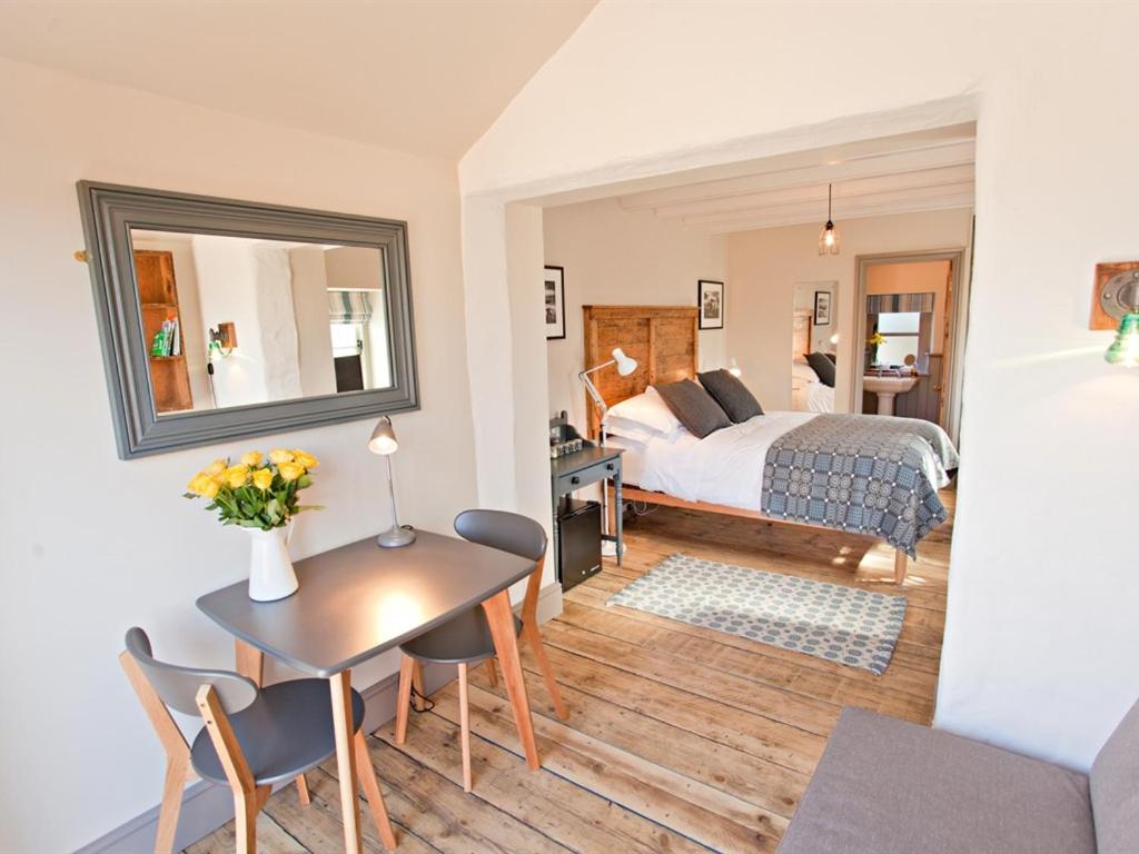 a bedroom with a bed and a table and chairs at Grove Park in Newport Pembrokeshire
