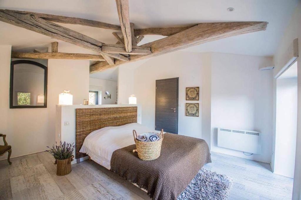 - une chambre avec un lit et un panier sur un banc dans l'établissement La grange du cleray, à Vallet