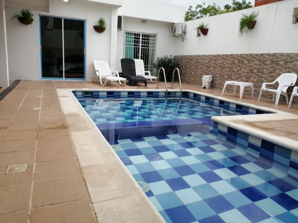 una piscina con suelo azul y blanco a cuadros en Casa El Mangle, en Cartagena de Indias