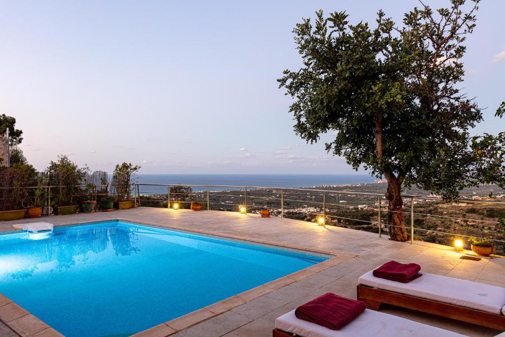 een zwembad met uitzicht op de oceaan bij Villa Candice in Maroulás