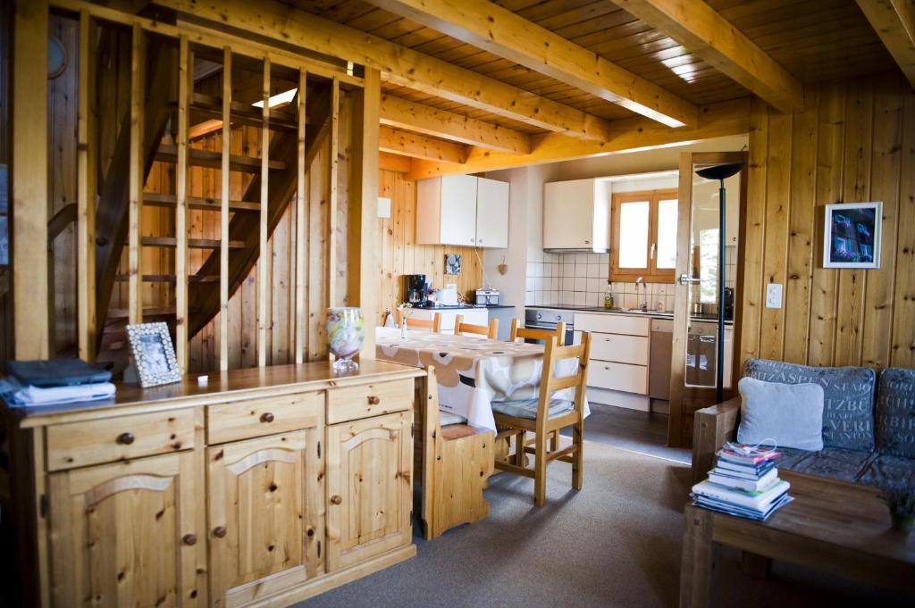 a kitchen with wooden cabinets and a table in a room at Fontannets QUIET & SUPERIOR chalets by Alpvision Résidences in Veysonnaz