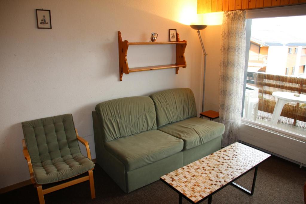 uma sala de estar com um sofá e uma cadeira em Combyre COMFORTABLE & CENTER apartements em Veysonnaz