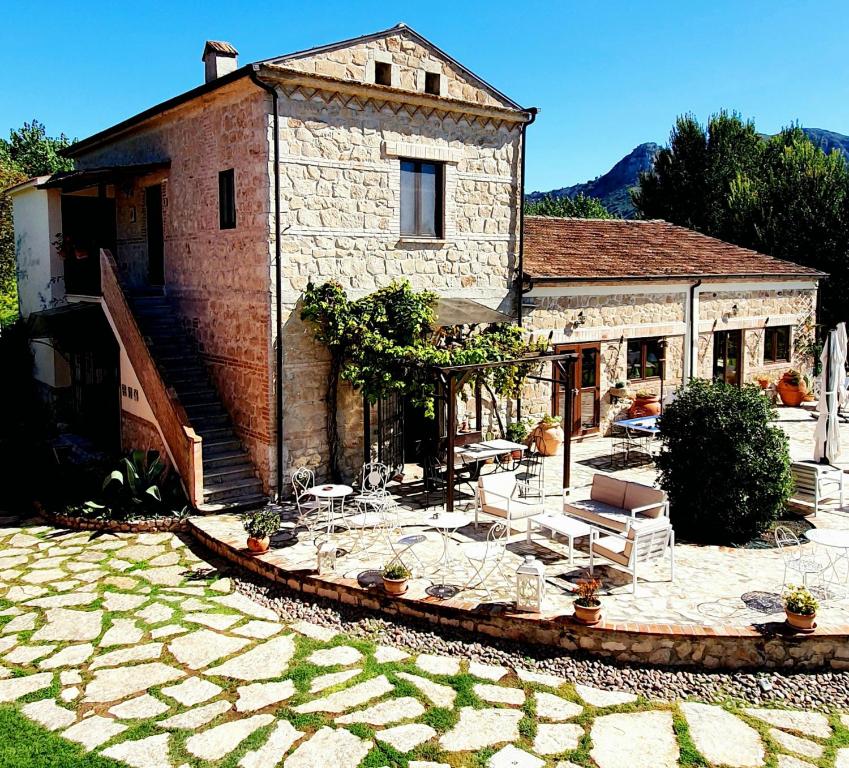 a stone house with a patio in front of it at AGRITURISMO iL PIOPPETO in Cassino