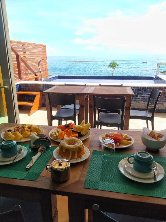 uma mesa com comida e vista para o oceano em Pousada Vila Dos Mares em Morro de São Paulo