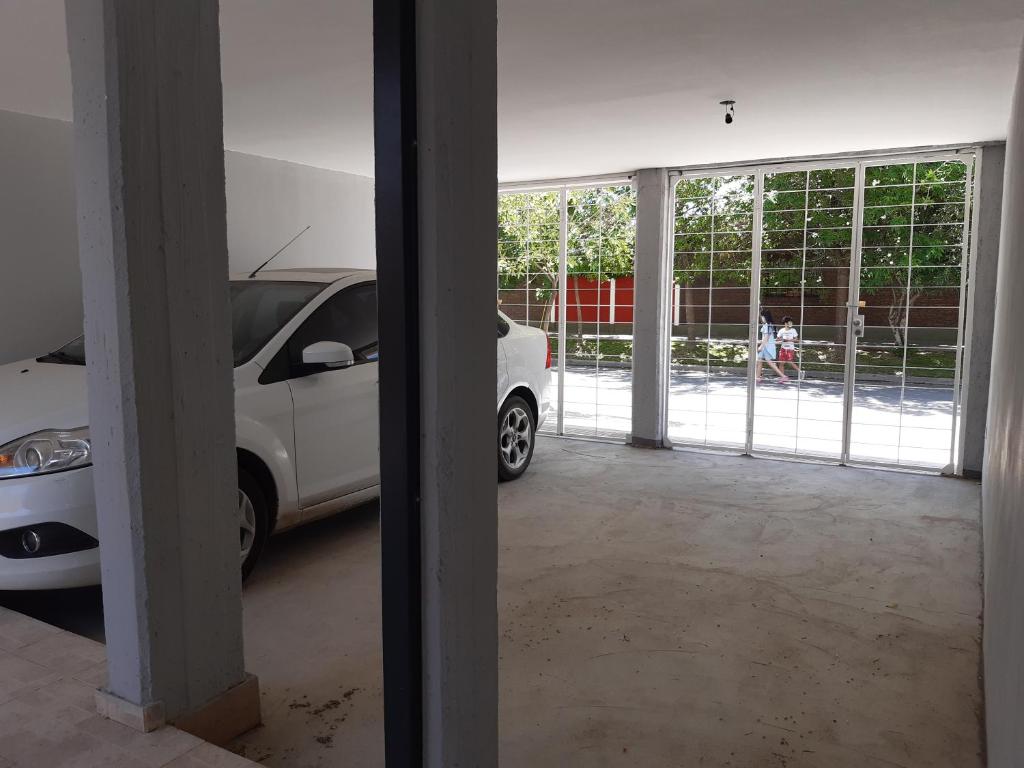 a garage with a white car parked in it at Departamento nuevo 2 dorm, parrilla, cochera in Neuquén