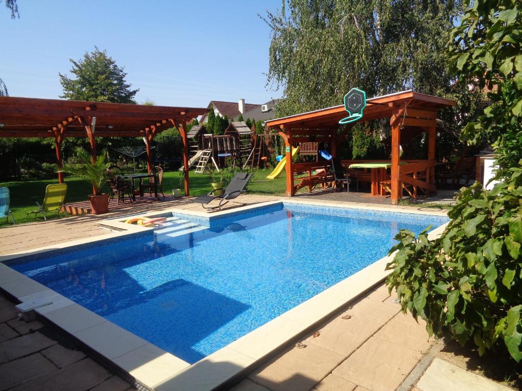 basen w ogrodzie ze stołem i krzesłami w obiekcie Patrícia Panzió w mieście Bük
