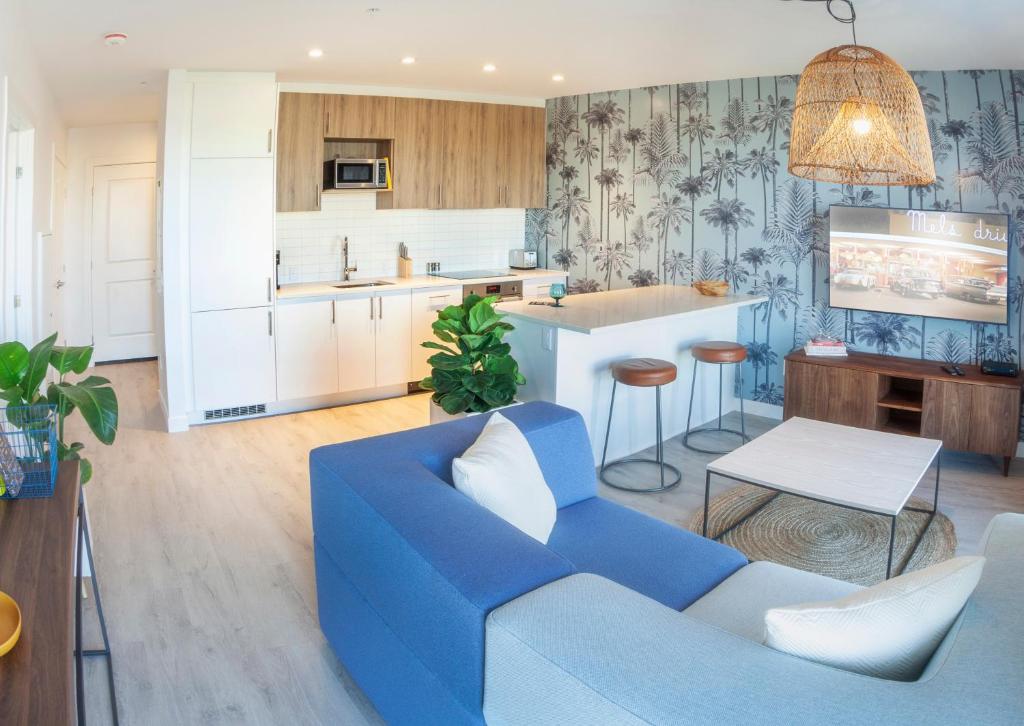 a living room with a blue couch and a kitchen at The Laundry Rooms - Waterloo in Waterloo