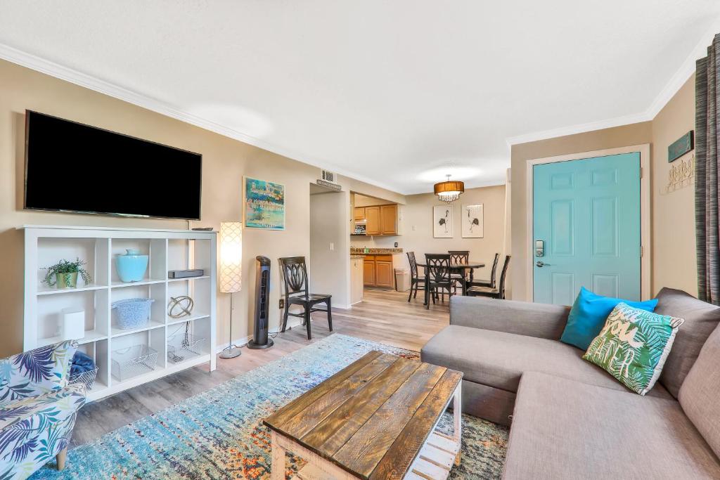 a living room with a couch and a flat screen tv at Clipper Cabana Beachwalk Condo in Saint Augustine