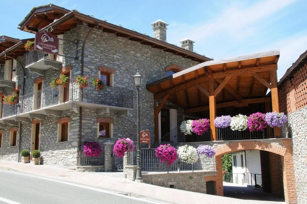 un edificio con macetas de flores en los balcones en Bed & Breakfast Lo Teisson en Aosta