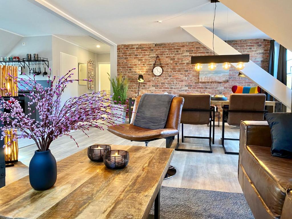 een woonkamer met een houten tafel en een bakstenen muur bij Schöne Ferienwohnungen teilweise mit Dachterrasse im Herzen von Itzehoe in Itzehoe