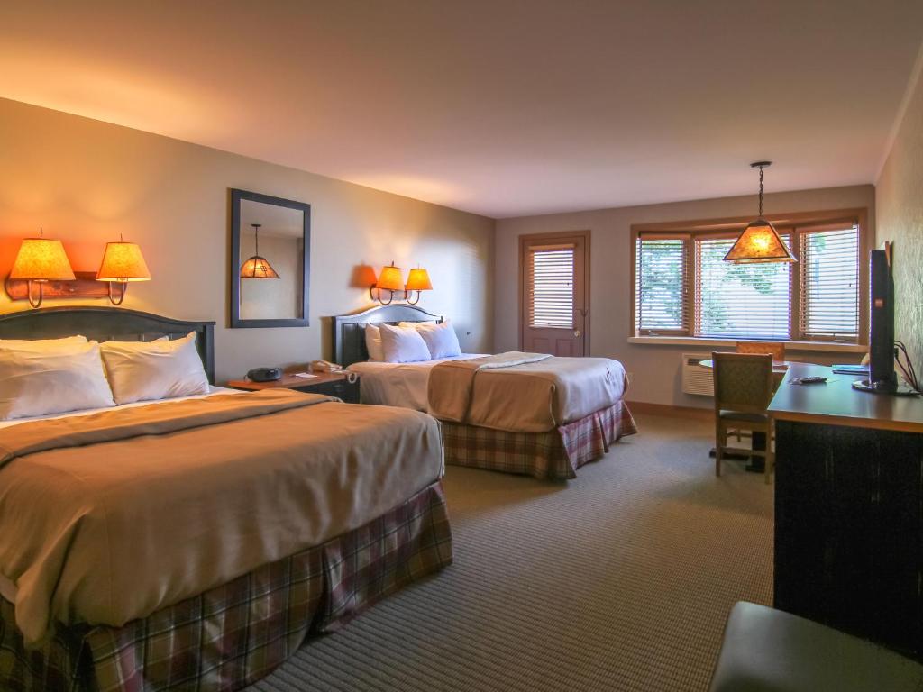 a hotel room with two beds and a desk at Crystal Mountain in Thompsonville