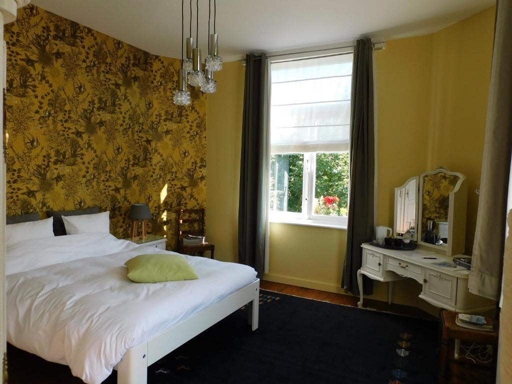 a bedroom with a bed with a mirror and a window at B&B Villa D'Hondt in Blankenberge