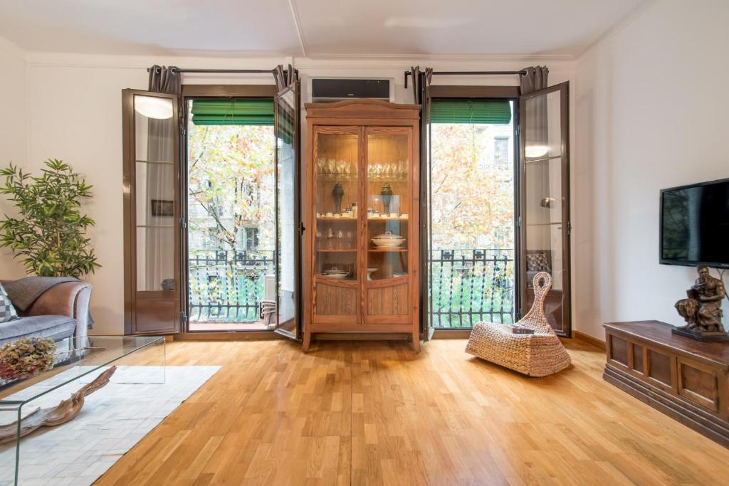 a living room with a wooden door and windows at Art Nouveau Apartment in Barcelona