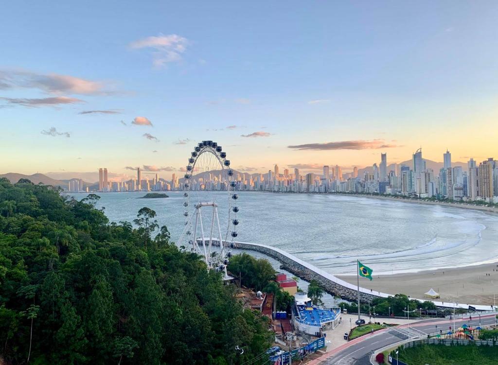 a city skyline with a ferris wheel and a beach at Lindo Apto no Terraços da Rainha in Balneário Camboriú