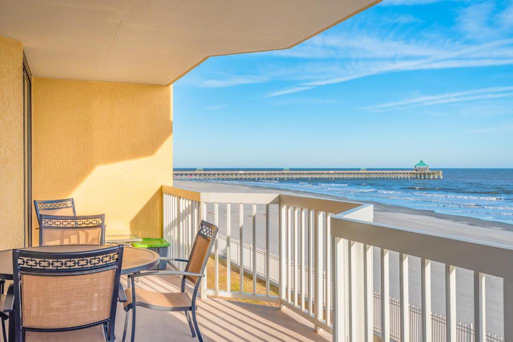 balcón con mesa, sillas y vistas al océano en 220 Charleston Oceanfront Villas Dolphin View, en Folly Beach