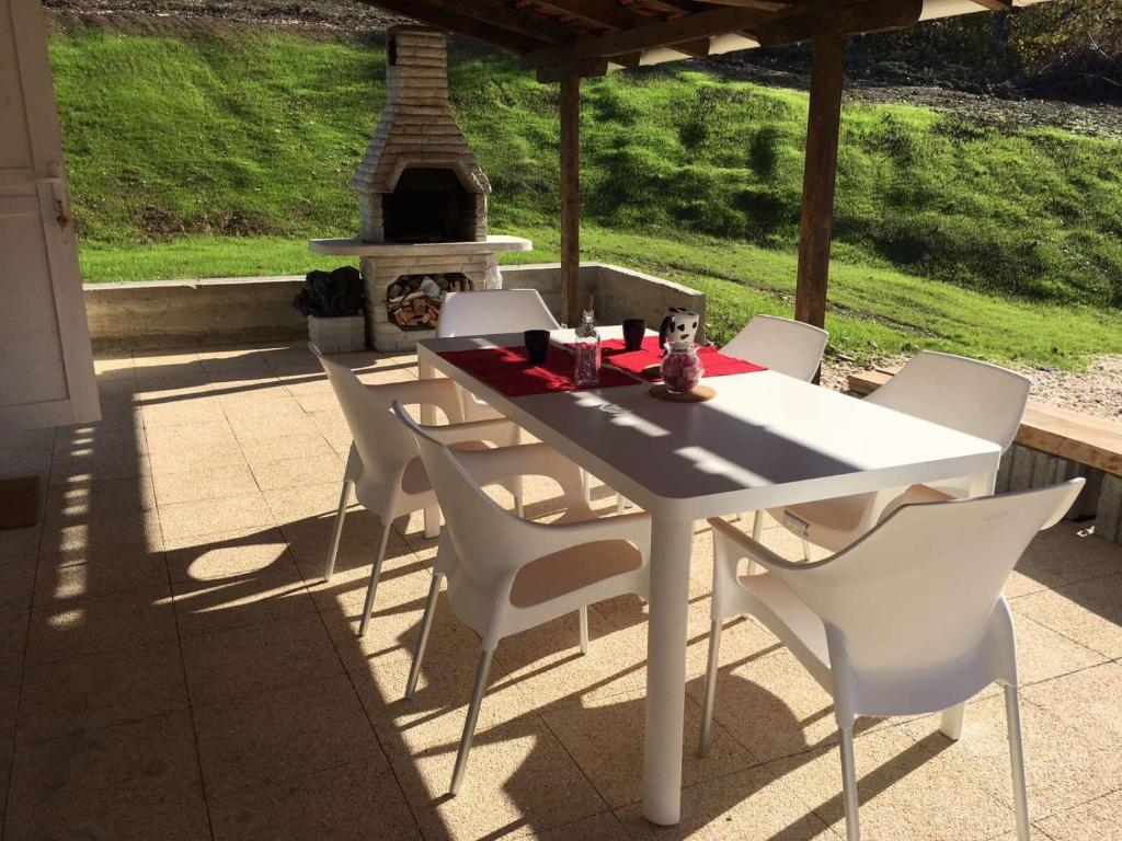 einen weißen Tisch und Stühle auf einer Terrasse mit Kamin in der Unterkunft Nina in Aranđelovac