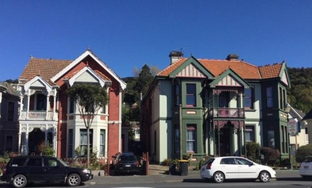 a row of houses with cars parked in front of them at Sahara Guest House in Dunedin