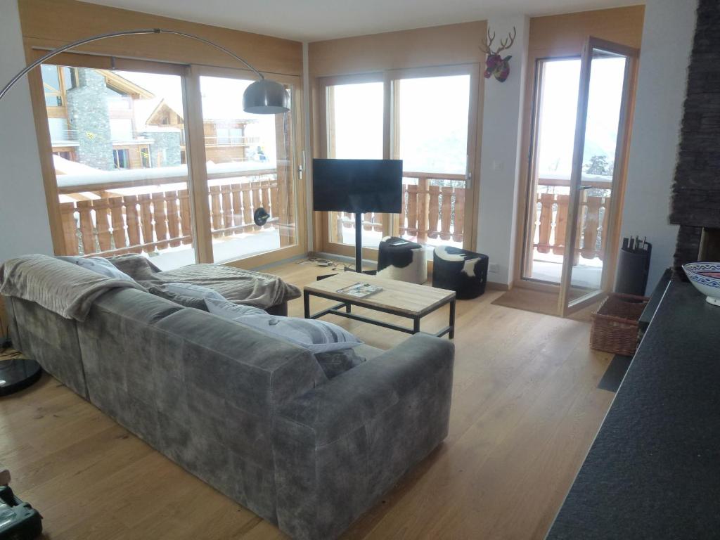 ein Wohnzimmer mit einem Sofa und einem Tisch in der Unterkunft Ski in Ski out LUXURY & MOUNTAIN apartments by Alpvision Résidences in Veysonnaz