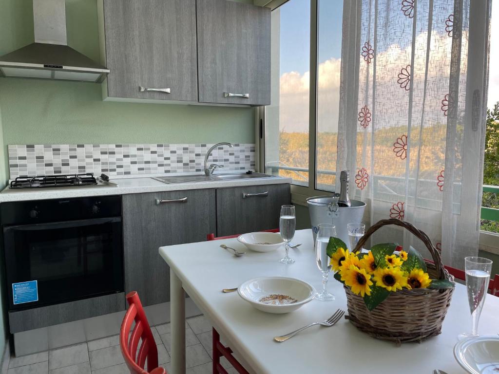 una cocina con una mesa con una cesta de flores. en Baia Verde Apartment, en Baia Verde
