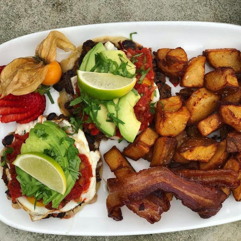 a plate of food with bacon potatoes and a sandwich at Harbour House Hotel in Ganges