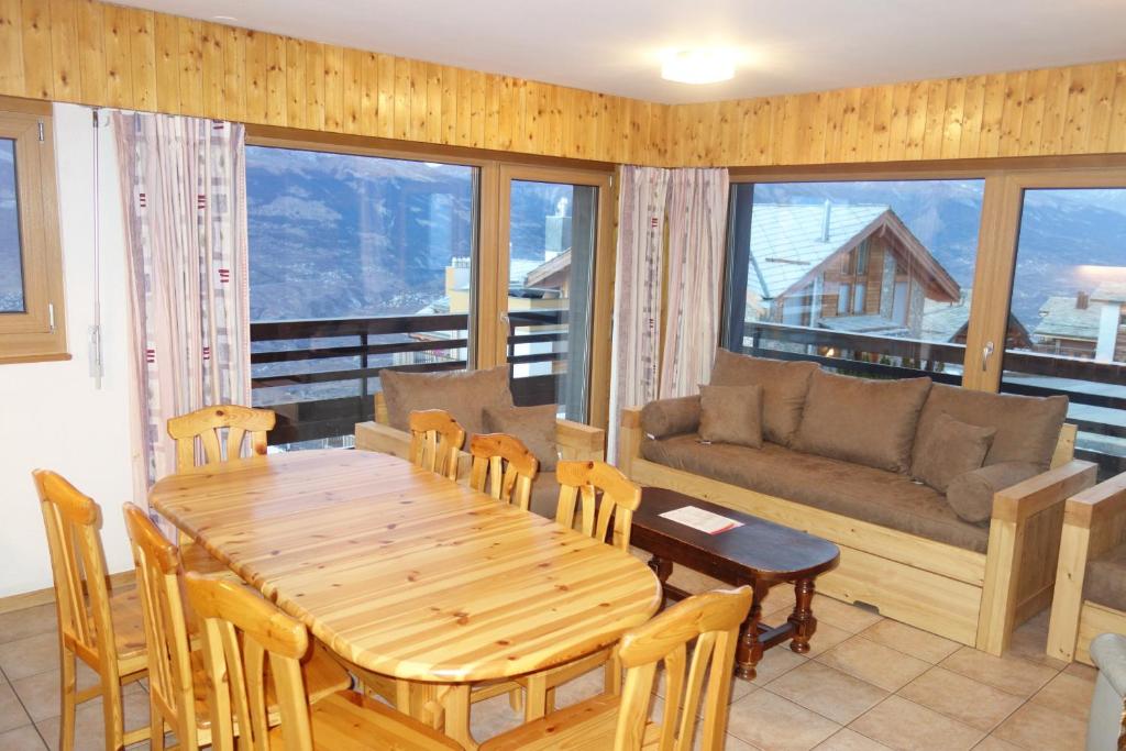 a living room with a wooden table and a couch at Mont Rouge VIEW & CENTER apartments by Alpvision Résidences in Veysonnaz