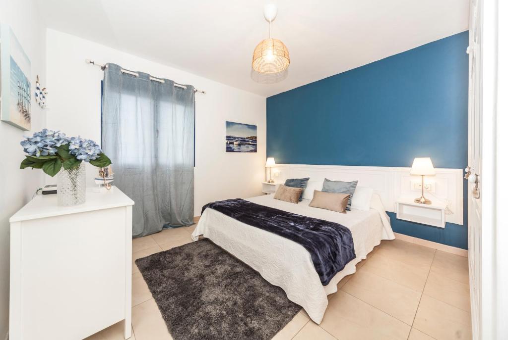 1 dormitorio con 1 cama grande y pared azul en Luxury Suite Sea Front III en Playa Honda