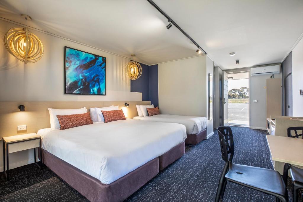 a hotel room with two beds and a desk at Nightcap at Gateway Hotel in Corio