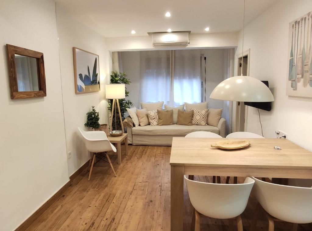 a living room with a couch and a table and chairs at Apartamento Playa in Valencia