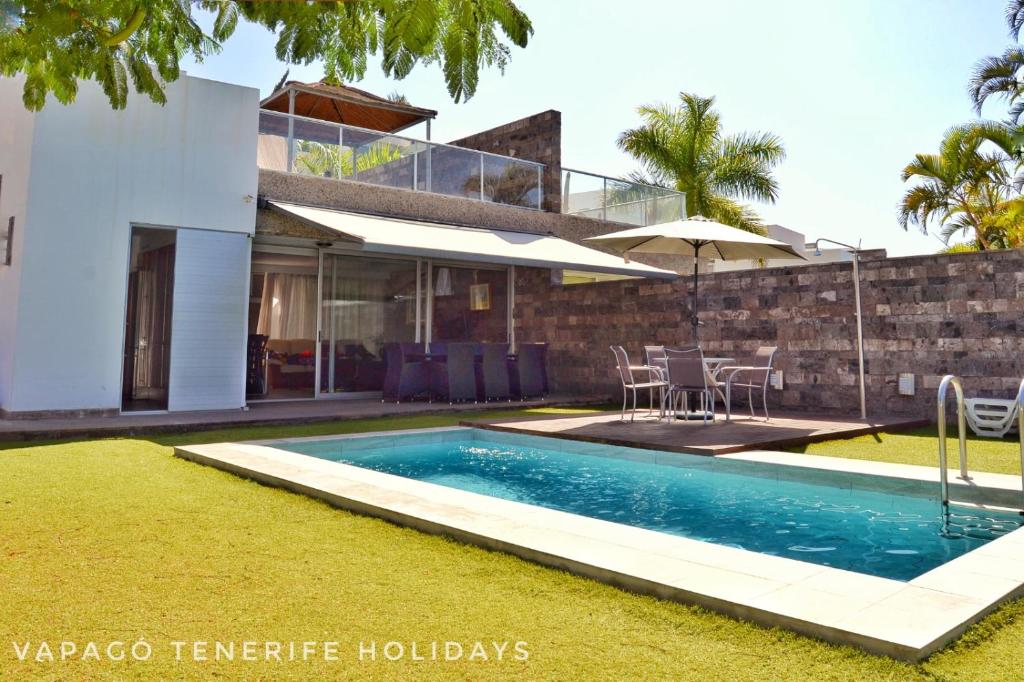 une maison avec une piscine en face d'une maison dans l'établissement Deluxe Villa with private pool El Duque, à Adeje