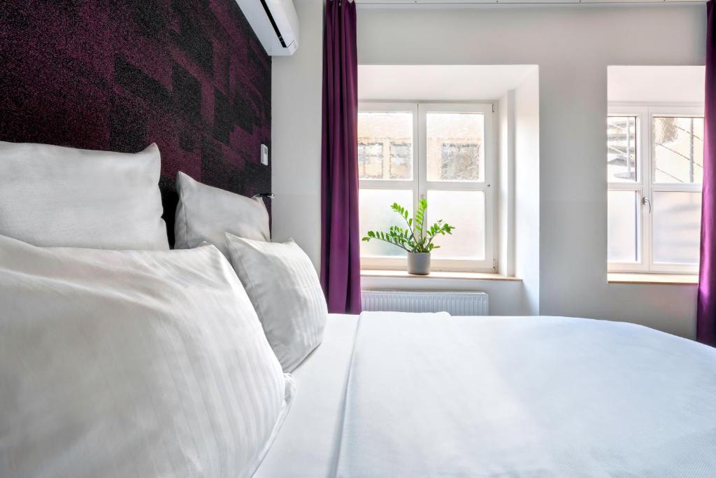 a bedroom with a white bed and a window at Design Hotel Wiegand in Hannover